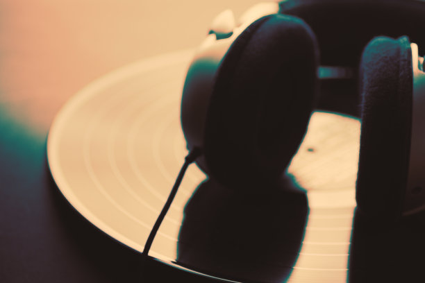 耳机躺在vintage black vinyl长播放唱片在vintage style与坚固的效果。抽象模糊形象用于音乐娱乐艺术的表现图片下载