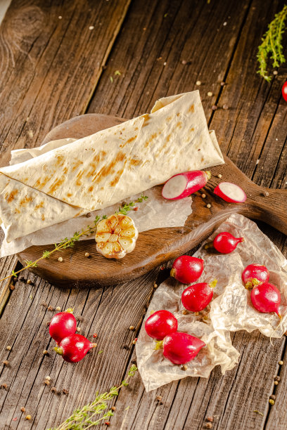 躺在一个老式的木桌上，在砧板上，多汁的烤肉沙瓦玛，有肉块，蔬菜，酱汁，深色的背景，特写，广角，全切，整个，樱桃番茄上图片下载