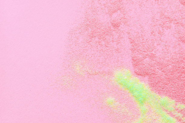 许多多色的亮片散布在粉红色的背景上。图片下载