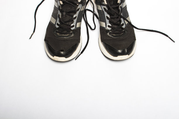 白色背景上有洞的旧的破旧的运动鞋。跑步、马拉松、超长马拉松、长时间锻炼的概念。平躺，俯视图图片下载