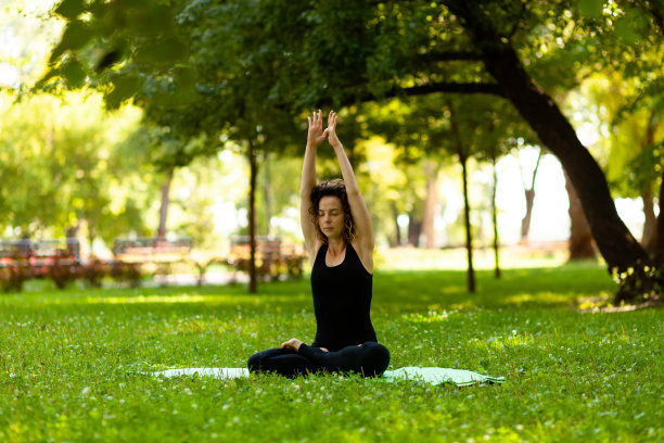 美丽恬静的女子在树下莲花坐姿。瑜伽与冥想，凝神与放松，与自然合一图片下载