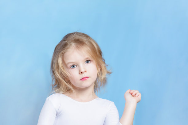 在光线工作室天使像金发女孩的肖像。漂亮的短发白种人小孩看着镜头。冷静冷静的女孩在中立的背景前拍摄图片下载