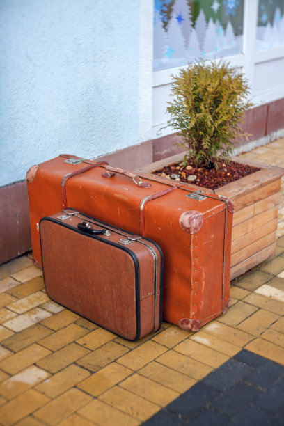 商店附近的人行道上放着一些装饰用的旧皮箱图片下载