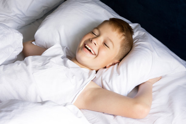 小男孩躺在卧室里微笑图片下载
