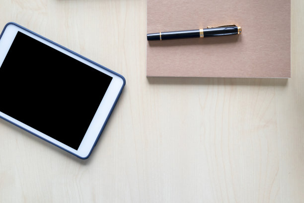 俯视图的办公桌与写字板，笔记本，钢笔在木制的背景图片下载