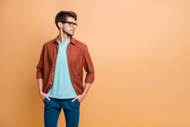 他的肖像，他漂亮，有吸引力，冷静，成功的内容棕色头发的人看一边手在口袋孤立的米色柔和的背景图片下载