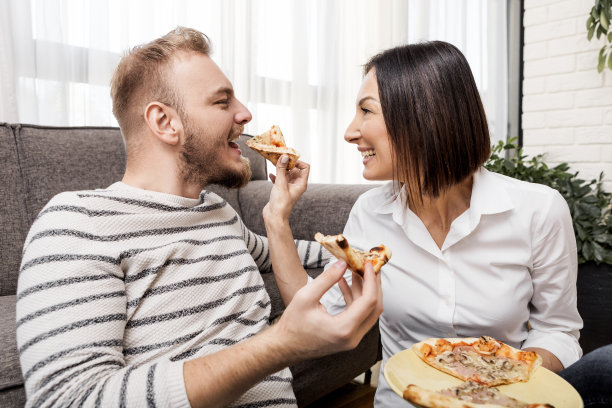 年轻夫妇在家吃披萨图片下载