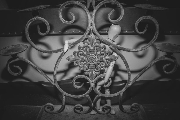 木制人体模型摆姿势在一个生锈的旧烛台图片下载