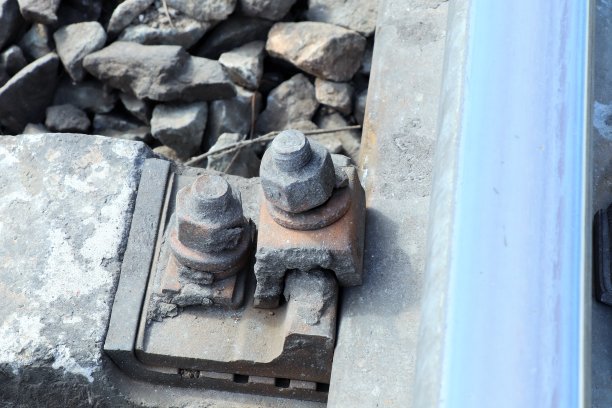 铁路上固定铁轨和枕木用的生锈旧的螺栓和螺母图片下载