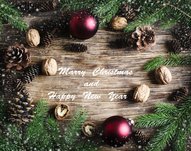 圣诞快乐，恭贺新禧。圣诞假日背景与冷杉树枝，松果和坚果。图片下载