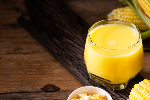 新鲜甜玉米汁(玉米奶)和玉米在木材背景图片下载