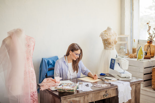 时装设计师的工作。在她的工作空间画草图的天才裁缝图片下载