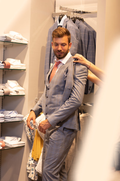 一个男人在男装店里试穿一件夹克图片下载