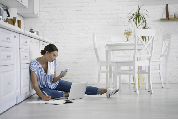 忙碌的女人做笔记，而工作在家库存照片图片下载