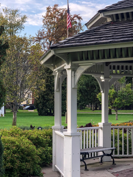城市公园的白色凉亭上挂着美国国旗图片下载