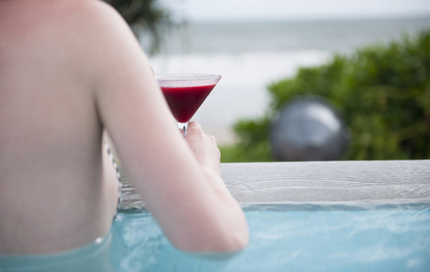 泳池里拿着鸡尾酒的女人图片下载
