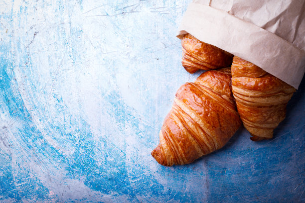 欧式早餐，纸包装的新鲜羊角面包。美味的街边小吃。顶部视图复制空间的文本图片下载