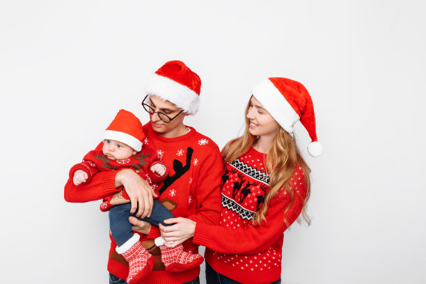 全家戴着圣诞帽，爸爸妈妈和小宝贝一起庆祝圣诞节图片下载