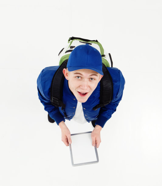 一个男人/一个人/一个十几岁的男孩/直接上方观看/全长/仰望18-19岁的成年英俊的人白人男性/年轻男子男孩/十几岁的男孩/学生/大学生/高中学生站立图片下载