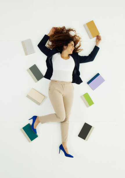 全长/一人/直接上方的视图/正面视图30-39岁的成年人美丽的卷发/长发波多黎各种族/拉丁美洲和西班牙裔的女性/年轻女性躺在白人背景前图片下载