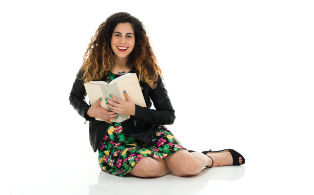 全长/一个30-39岁的成年人美丽的波多黎各种族/拉丁美洲和西班牙裔的女性/年轻女性/一个年轻女性学生/大学学生坐在地板上的白人背景图片下载