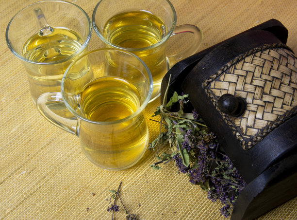 从玻璃玻璃杯中混合消炎草药制成的草药茶。木盒里的药草。图片下载