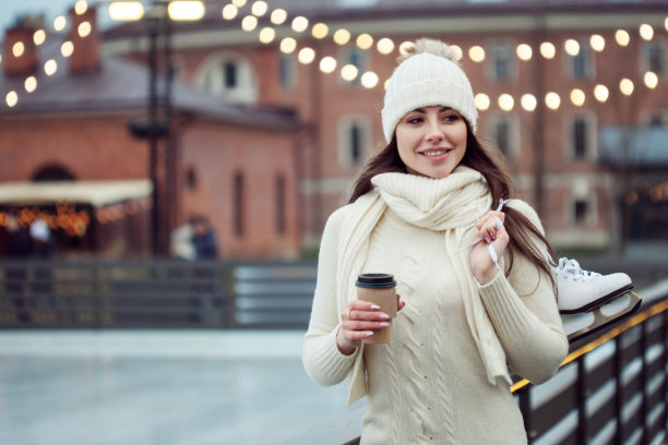 公园里滑冰场附近的迷人年轻女子。带着冰鞋微笑的黑发女子图片下载
