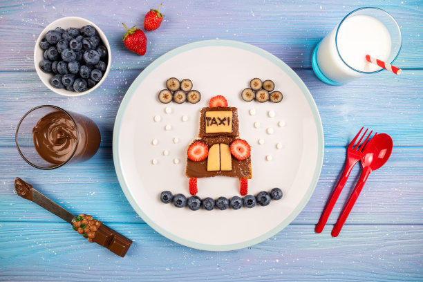 孩子们的早餐，有三明治，浆果和牛奶。有趣的出租车三明治，巧克力酱，浆果和奶酪。孩子们食物的想法图片下载