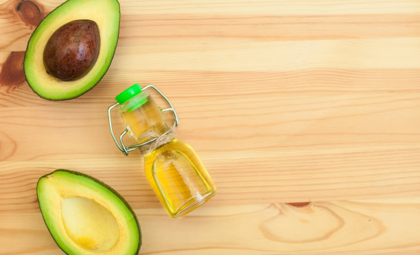 鳄梨和鳄梨油在瓶子上的木材背景。前视图。副本的空间。图片下载