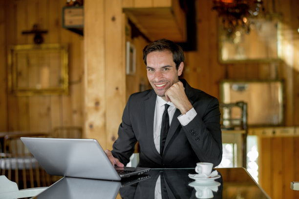 年轻的商人在咖啡店用笔记本电脑工作图片下载