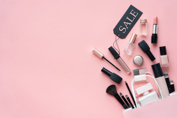 化妆化妆品香水女性产品配件从购物袋倒在粉红色平铺背景，美容产品低价折扣零售提供网上购买，俯视图以上复制空间图片下载