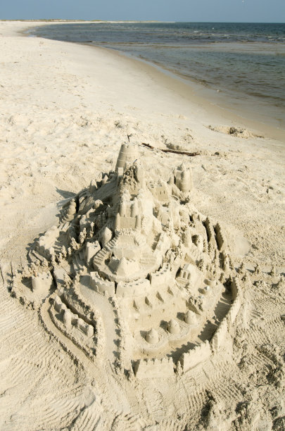 弯曲海岸线上的沙堡图片下载