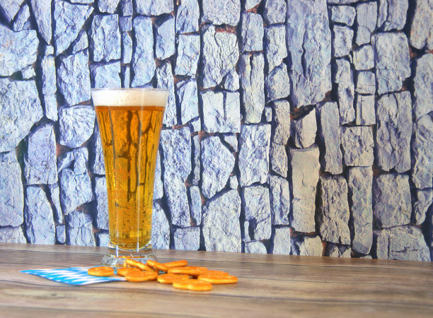 木桌上放着一杯淡啤酒，一个脆饼和一张有象征意义的餐巾。图片下载