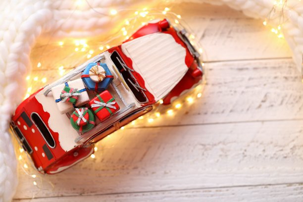 圣诞车与礼物，闪亮的花环和针织围巾在破旧别致的灯光背景。圣诞节的时间。副本的空间。图片下载