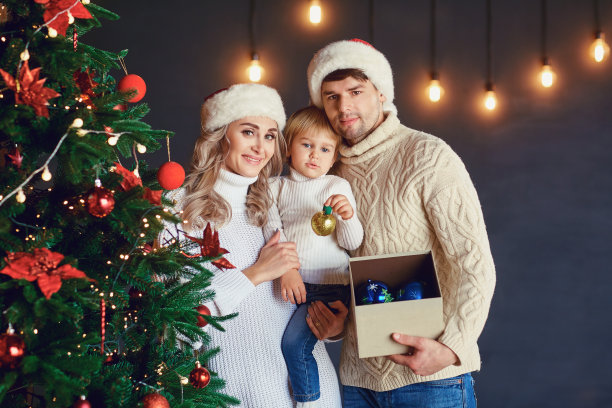 圣诞节时，家人在房间里装饰圣诞树图片下载