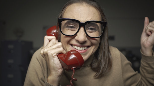 女人一边说着电话一边耸耸肩图片下载