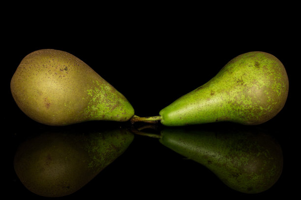 新鲜的绿色梨孤立在黑色玻璃上图片下载