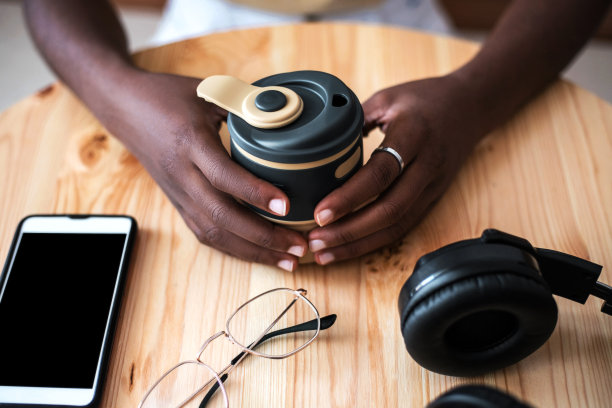 年轻黑人女孩在咖啡馆用智能手机听音乐。图片下载