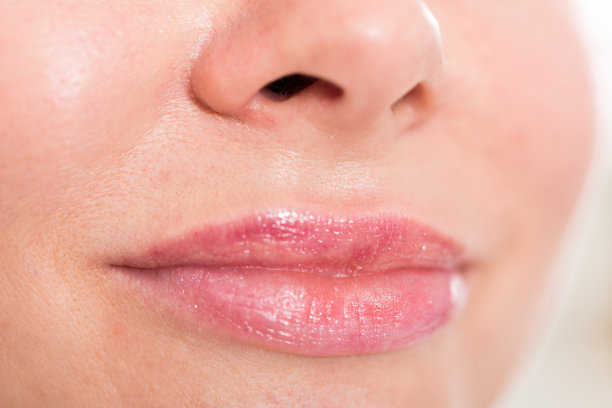 特写女孩的嘴唇与干净的口红化妆。宏唇彩化妆图片下载