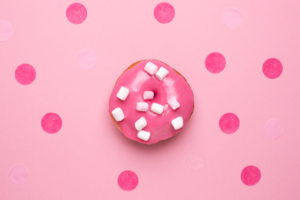 粉红色的甜甜甜圈和棉花糖在粉红色的背景平躺图片下载