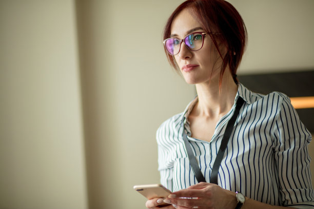 微笑的年轻商务女性在酒店用智能手机聊天的照片图片下载