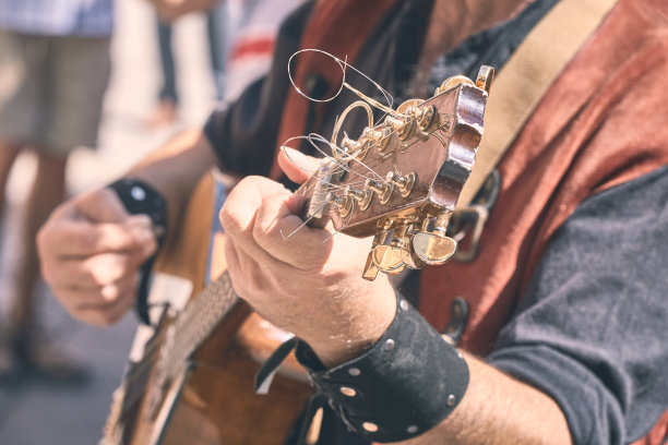 街头音乐家在城市的街道上弹奏曼陀林。水平的。图片下载