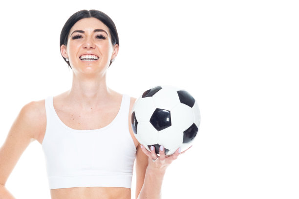 一个人/正面视图/腰部以上的20-29岁的成年人美丽/高个子/长发高加索年轻女性/女足球运动员在白色背景前穿着运动胸罩/弹力纤维/打底裤谁是微笑/快乐/愉快图片下载