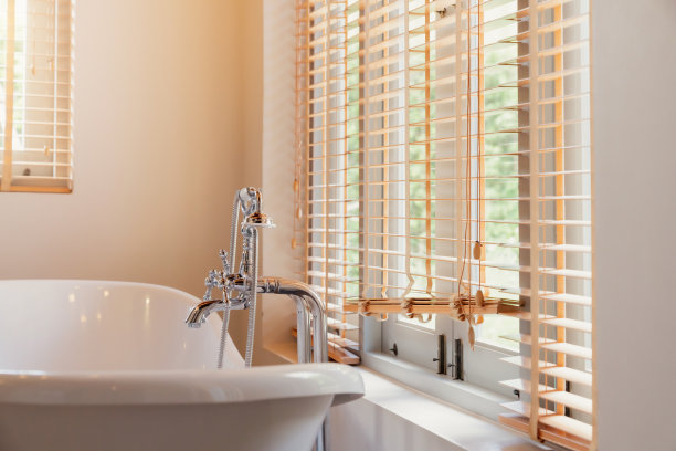 白色浴缸，有大窗户和遮阳帘图片下载