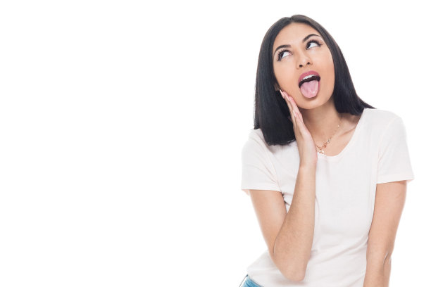 一个人/正面视图/腰部以上的20-29岁的成年美丽的拉丁美洲和西班牙裔种族的女性/年轻女性站在白色背景穿着t恤/衬衫谁是一个脸/幽默/古怪/酷的态度图片下载