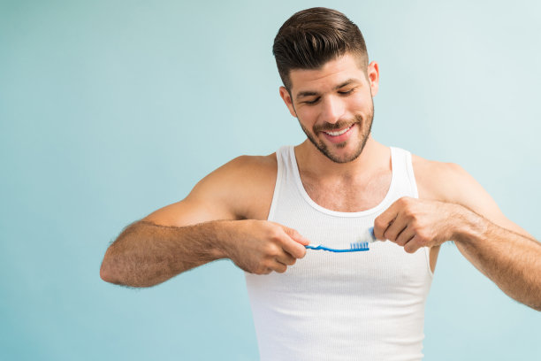 快乐的男性在工作室刷牙图片下载