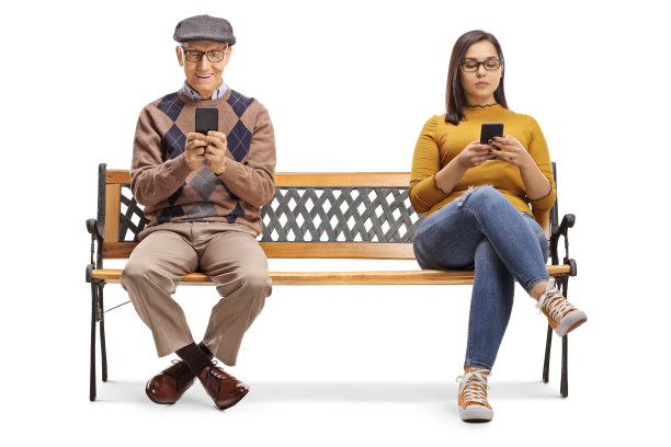 一位老先生和一位年轻女士坐在长椅上打手机图片下载
