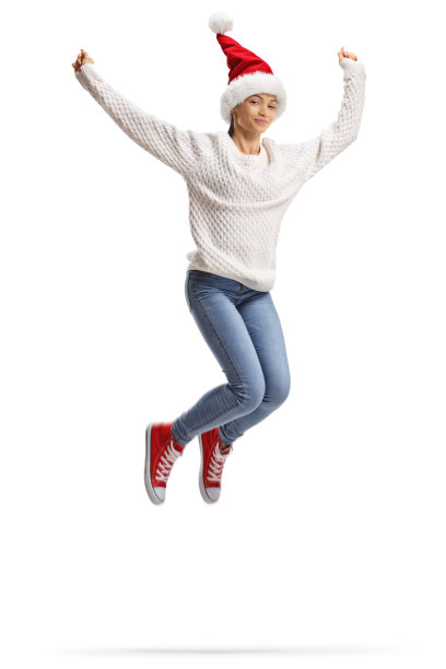 戴着圣诞帽的快乐年轻女子跳起来了图片下载