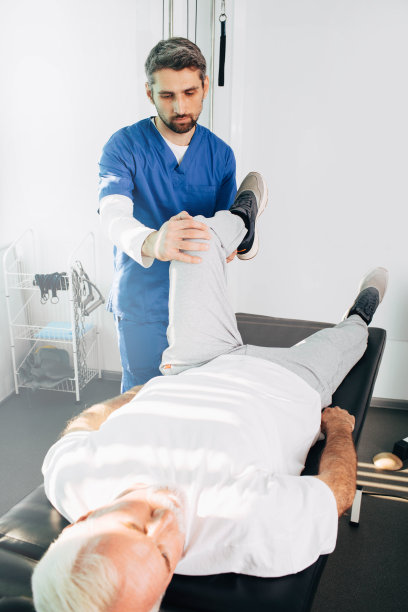 理疗师正在治疗一名男子的腿部受伤。和他的治疗师一起训练的资深男人。关节、膝盖、腿部疼痛治疗图片下载