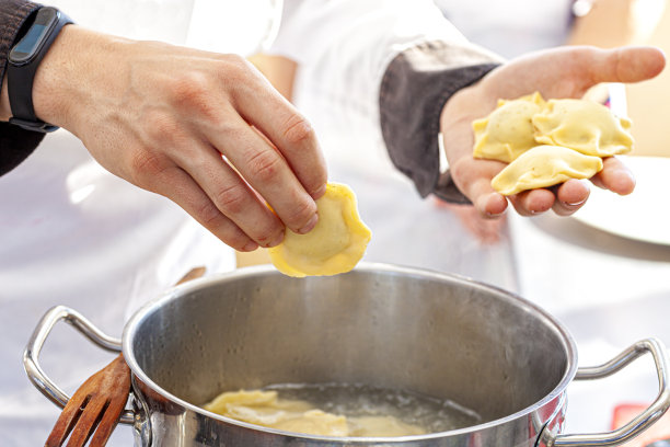 厨师将饺子放入沸水中图片下载